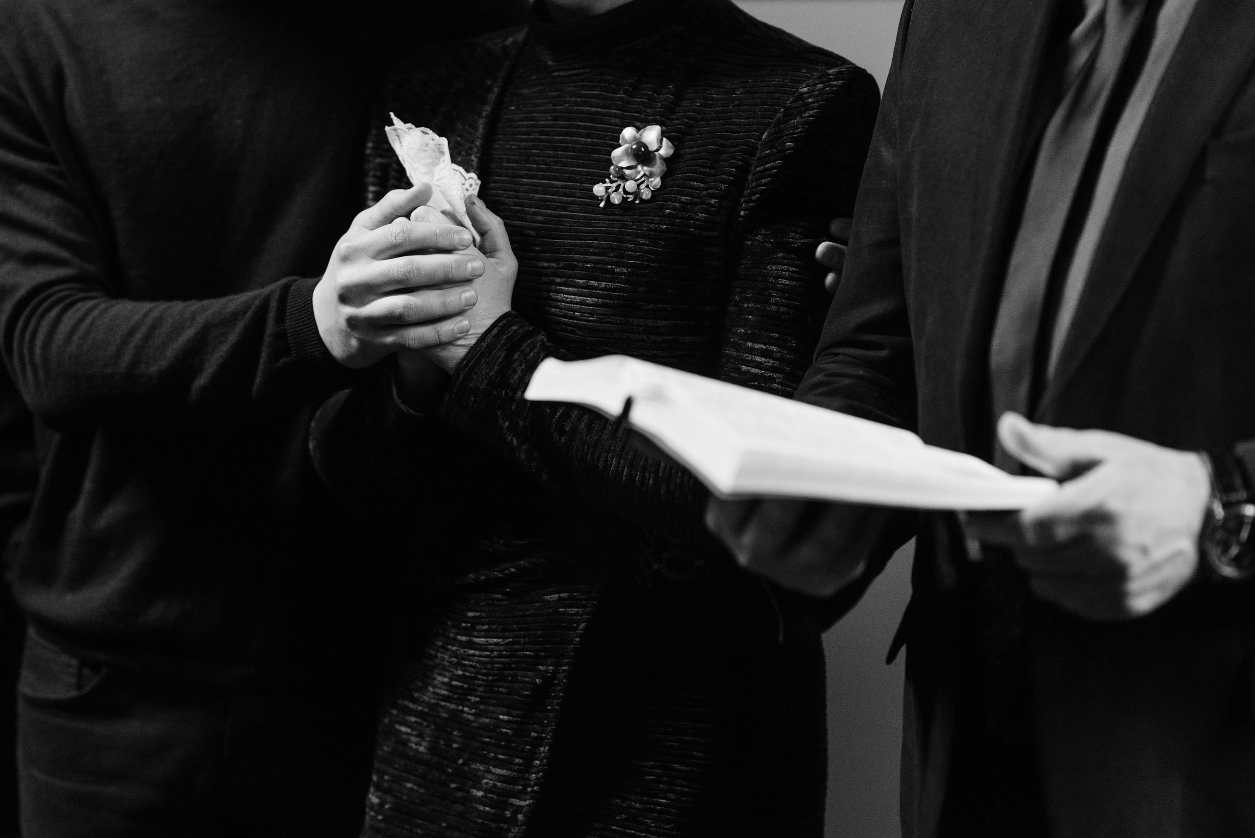 Grayscale Photo of a Person Holding a Bible